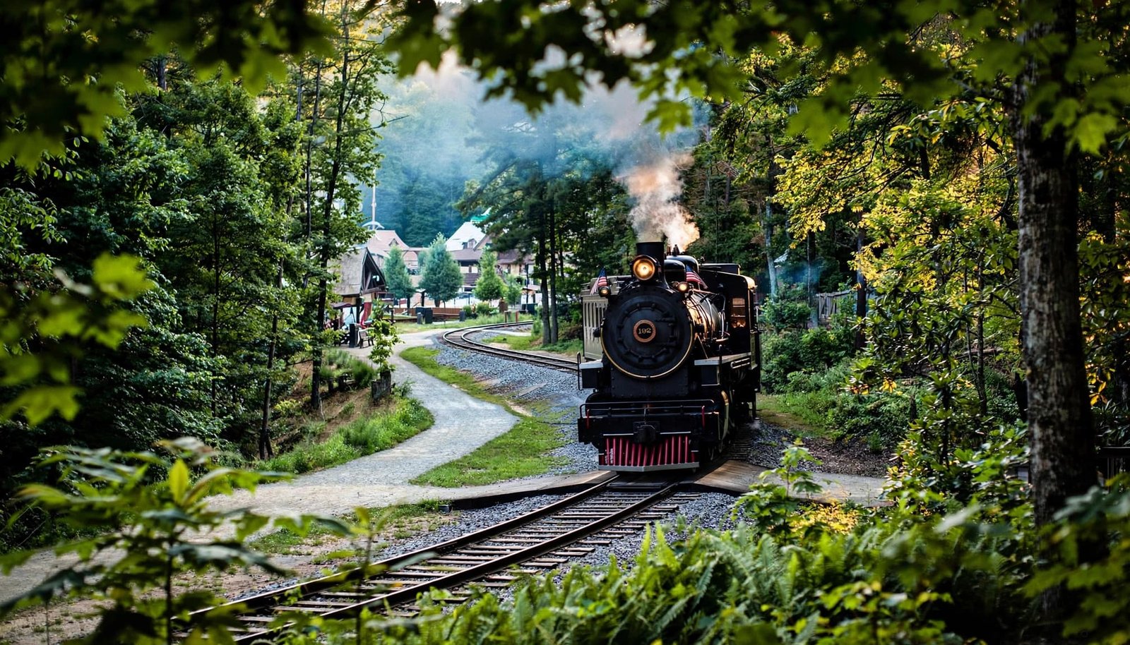 Autism-Friendly Dollywood: A Flexible Family Plan A steam train rounds a wooded track with a light plume of steam.